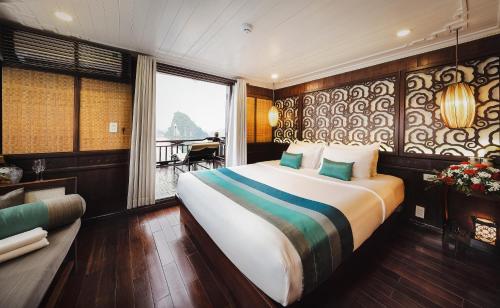 a hotel room with a large bed and a couch at Bhaya Halong Cruises in Ha Long