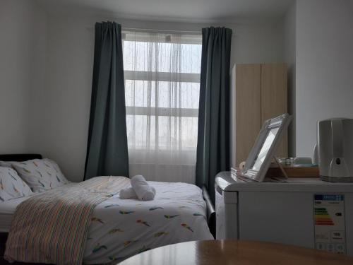 a bedroom with a bed and a window and a table at A Quiet & Comfortable 4 Bedroom house in Manchester