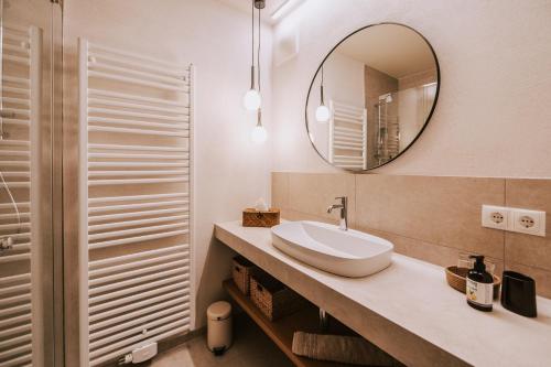 een badkamer met een wastafel en een spiegel bij Hotel Marvia in Schwarzenberg im Bregenzerwald