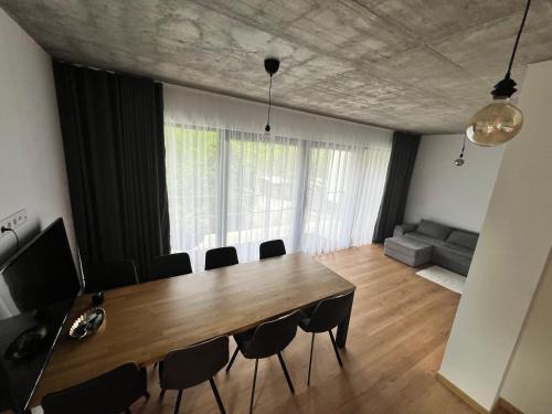a dining room with a table and chairs and a couch at Jamy House in Habovka