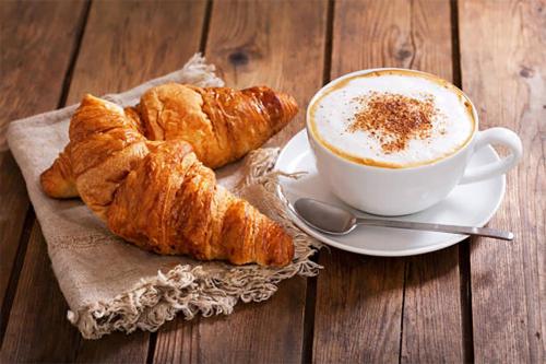 einen Teller Croissants und eine Tasse Kaffee auf dem Tisch in der Unterkunft Suite Cobega Appartamento in centro città in Taranto