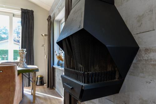 a black fireplace in a living room at Luxe en comfort aan bos - geniet van rust & natuur in Putten