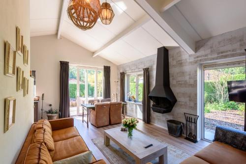 a living room with a couch and a table at Luxe en comfort aan bos - geniet van rust & natuur in Putten