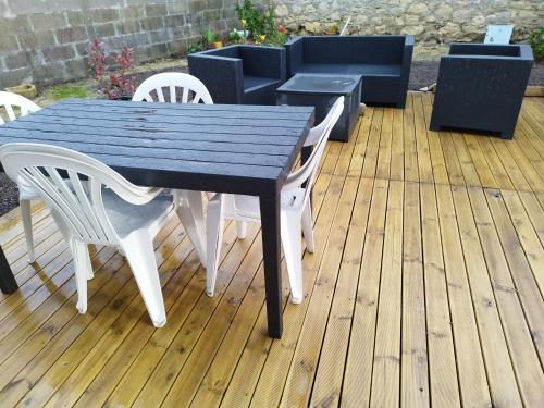 - une table de pique-nique et des chaises sur une terrasse en bois dans l'établissement Hortensia, à Grandcamp-Maisy