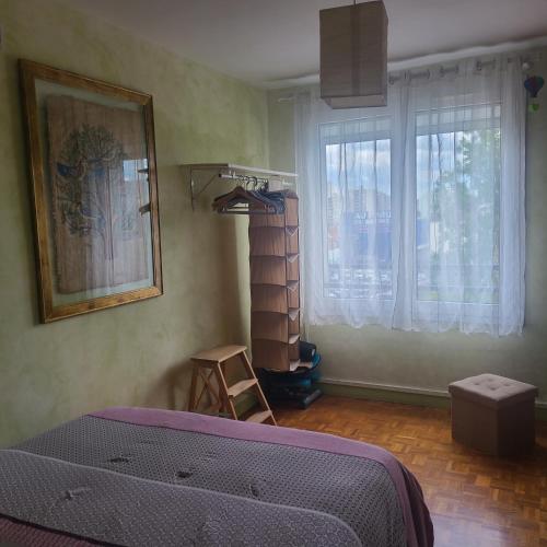 une chambre avec un lit dans une pièce avec des fenêtres dans l'établissement Grand 2 pièces - Proche Métro & Stade de France, à Saint-Denis