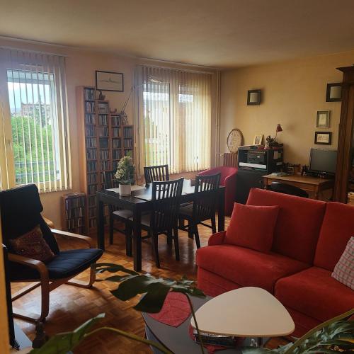 un salon avec un canapé rouge et une table dans l'établissement Grand 2 pièces - Proche Métro & Stade de France, à Saint-Denis