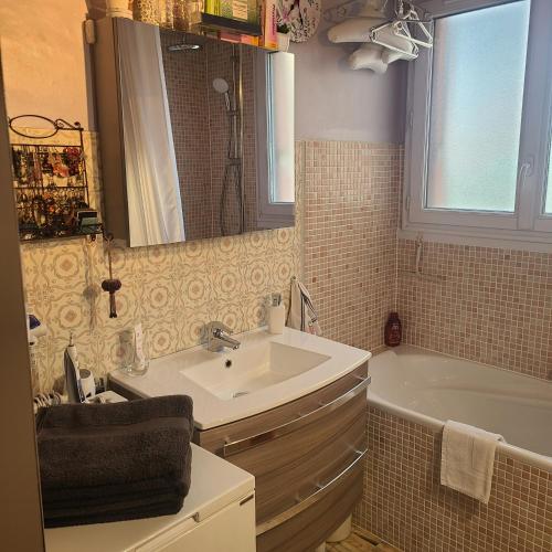 une salle de bain avec un lavabo et une baignoire dans l'établissement Grand 2 pièces - Proche Métro & Stade de France, à Saint-Denis