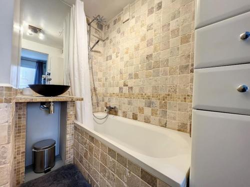 La salle de bains est pourvue d'un lavabo et d'une baignoire avec lavabo. dans l'établissement Superbe 2 pièces au calme absolu, à Cannes