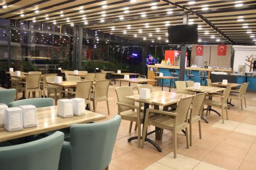 comedor con mesas y sillas y TV en CihanTürk Hotel, en Marmaris