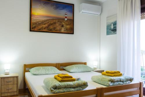 una camera con due letti con asciugamani gialli di Seaview Apartment Lighthouse with sunny balcony a Kastav (Castua)