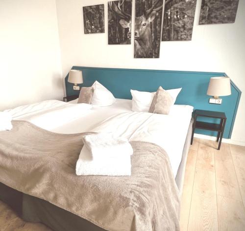 a bedroom with a large bed with a blue headboard at Berghotel HARZ in Hahnenklee-Bockswiese