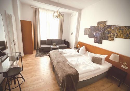 a bedroom with a bed and a chair and a couch at Berghotel HARZ in Hahnenklee-Bockswiese