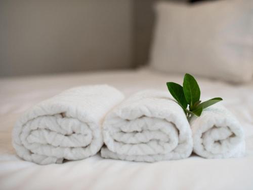 a group of towels with a green leaf on a bed at Brooklyn Blok in Pretoria