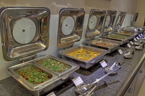 a row of trays of food on a counter at The Radiant Swan in Dahej