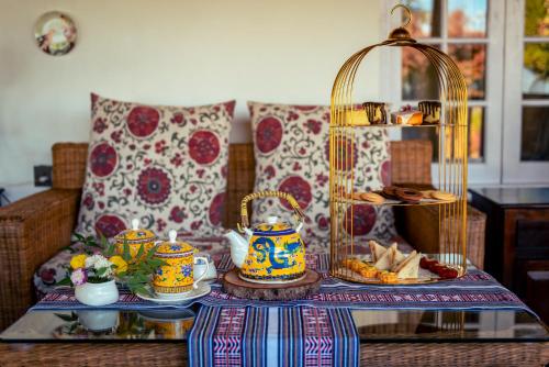 a table with a tray of food and a tea set at The Temi Bungalow South Sikkim in Namchi