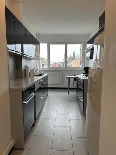 une grande cuisine avec une grande fenêtre et une table dans l'établissement L'escapade chez Laurent et Céline, à Mulhouse