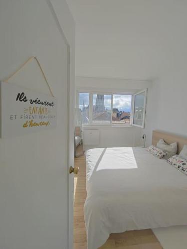 une chambre avec un lit blanc et une fenêtre dans l'établissement L'escapade chez Laurent et Céline, à Mulhouse