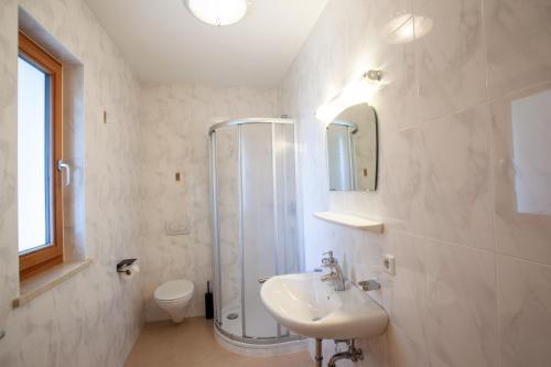 a white bathroom with a shower and a sink at Hof Schupfer - Alpstay in Naturno