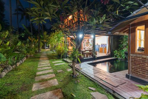 a garden with a tree in the middle of a house at Tahlia's Villa in Sorongjukung