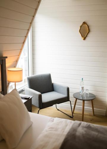 a bedroom with a bed and a chair and a table at RATSKELLER Hotel & Restaurant in Kröv