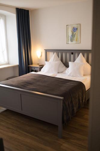 a bedroom with a large bed with white pillows at RATSKELLER Hotel & Restaurant in Kröv