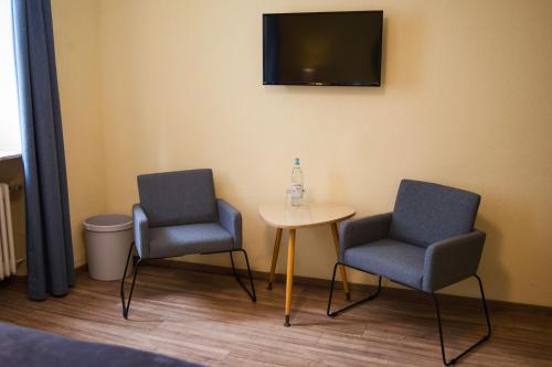 a room with two chairs and a table and a tv at RATSKELLER Hotel & Restaurant in Kröv