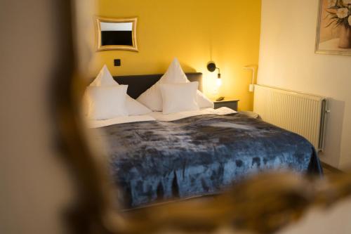 a bedroom with a large bed with white pillows at RATSKELLER Hotel & Restaurant in Kröv