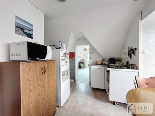 une cuisine avec des appareils blancs et un grenier dans l'établissement Appartement place Rubben - 2 pas de la Mer, à Bray-Dunes