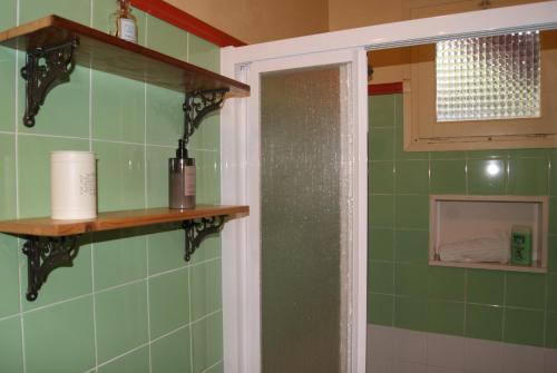 班約萊斯的住宿－Apartamento con encanto Can Brugada，浴室设有绿色瓷砖墙壁和架子