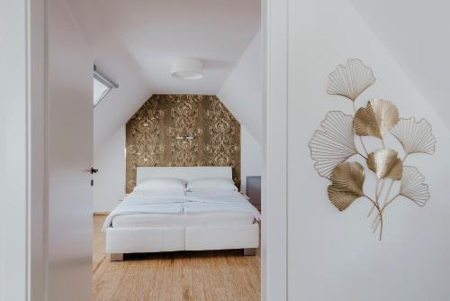 a bedroom with a white bed and a wall at Ferienhaus am HerbstHof in Leutschach