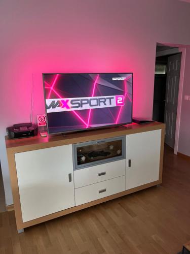 a flat screen tv on top of a white entertainment center at Apartman Dada in Krapinske Toplice