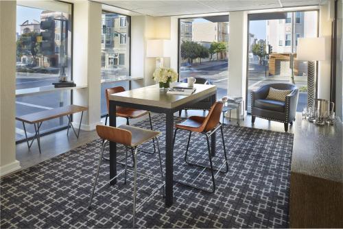 a dining room with a table and chairs and windows at Buena Vista Motor Inn in San Francisco