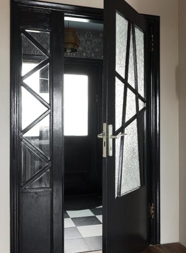 an open black door with a window in a room at S26 Boutique apartment in Stykkishólmur