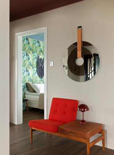 a living room with a red chair and a mirror at S26 Boutique apartment in Stykkishólmur