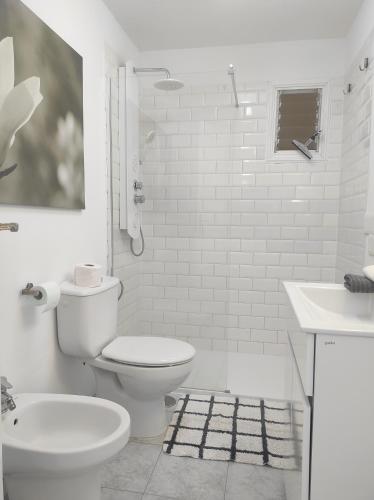 La salle de bains blanche est pourvue de toilettes et d'un lavabo. dans l'établissement Apartamento Naranja, incredible ocean view, à Puerto de Santiago