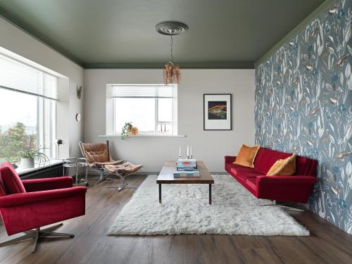 a living room with two red chairs and a table at S26 Boutique apartment in Stykkishólmur