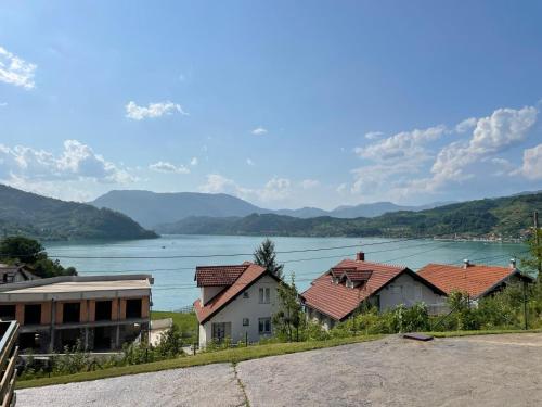 a view of a lake with houses and mountains at Vila Sunsets in Konjic