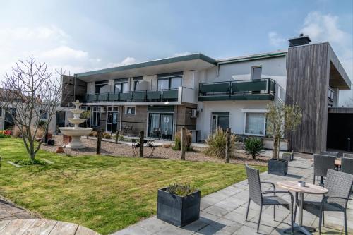 an apartment building with a patio and a garden at Hotel Rooms in Breskens