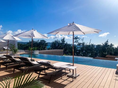 a group of chairs and umbrellas next to a swimming pool at Mandarin Nest Boracay in Boracay