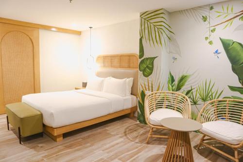 a bedroom with a bed and two chairs and a table at Mandarin Nest Boracay in Boracay