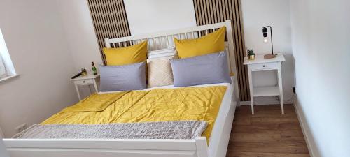 a small bedroom with a bed with yellow sheets and pillows at Ferienwohnung Fred in Darscheid