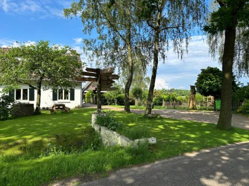 a house with a wooden sign in the grass at De Hazeldonck in Gemert