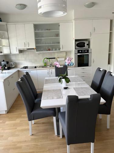 a kitchen with a white table and black chairs at Apartman Dada in Krapinske Toplice