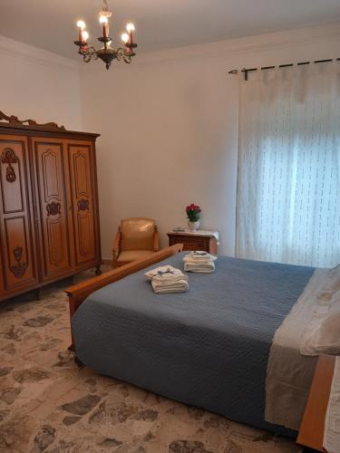 Raffadali的住宿－Casa al centro，一间卧室配有一张床、一把椅子和一个吊灯。