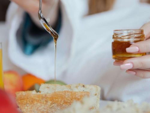 a person is pouring honey onto a piece of bread at Pullman Paris La Défense in Courbevoie