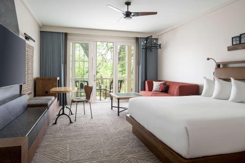 Cedar CreekにあるHyatt Regency Lost Pines Resort and Spaのベッドルーム1室(ベッド1台付)、リビングルームが備わります。