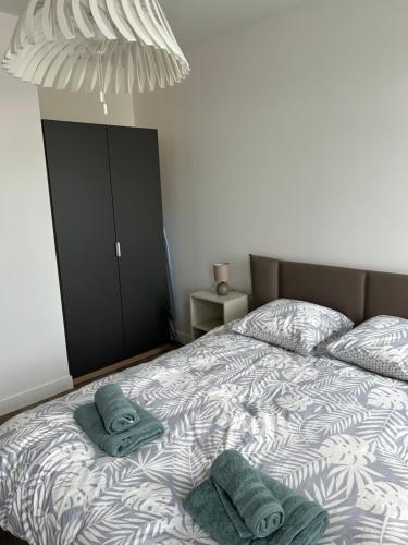 une chambre avec un lit avec deux serviettes dessus dans l'établissement Appartement Trevieres 2eme étage, à Trévières