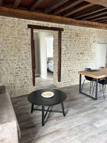 un salon avec un canapé et une table dans l'établissement Appartement Trevieres 2eme étage, à Trévières