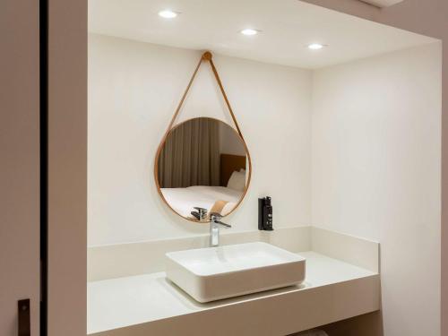 a bathroom with a white sink and a mirror at ibis Catanduva in Catanduva