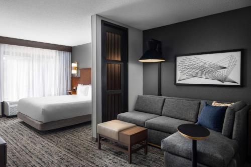 um quarto de hotel com uma cama e um sofá em Hyatt Place Indianapolis Airport em Indianápolis
